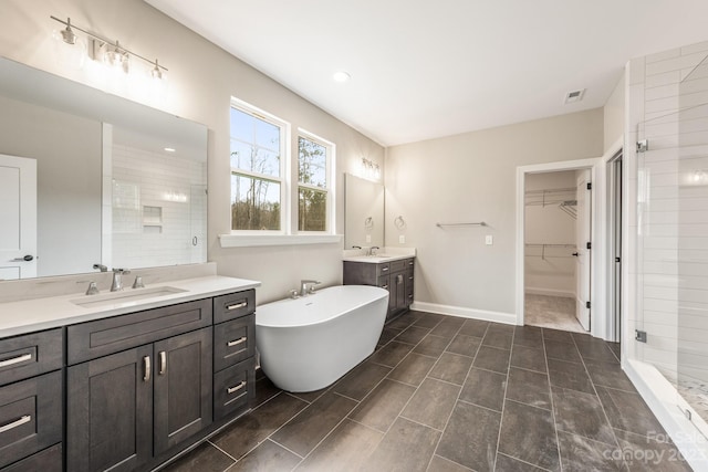 bathroom featuring shower with separate bathtub, tile flooring, large vanity, and dual sinks