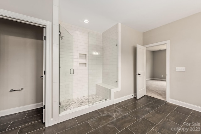 bathroom featuring a shower with door and tile flooring