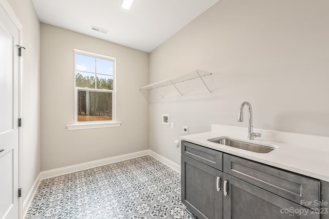 laundry room with electric dryer hookup, light tile floors, sink, cabinets, and washer hookup