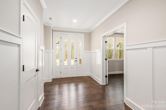 foyer entrance featuring crown molding, dark wood-type flooring, and plenty of natural light