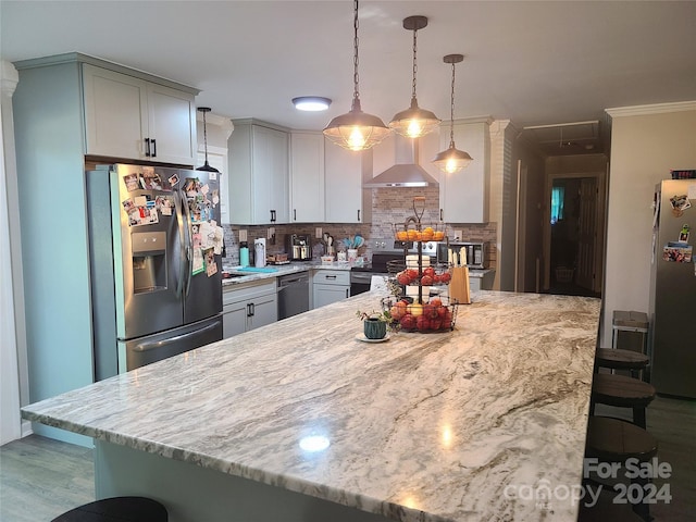 kitchen featuring dark hardwood / wood-style flooring, appliances with stainless steel finishes, a breakfast bar area, decorative light fixtures, and backsplash