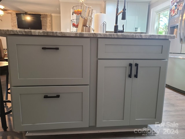 details featuring gray cabinetry, stone countertops, hardwood / wood-style flooring, and stainless steel fridge with ice dispenser