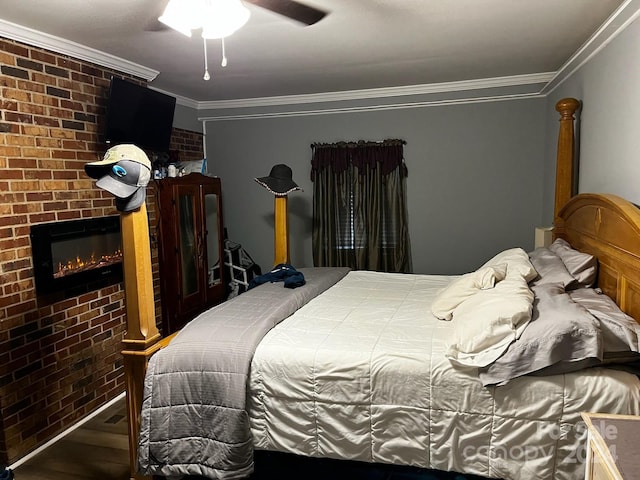 bedroom with ceiling fan, crown molding, hardwood / wood-style floors, a fireplace, and brick wall