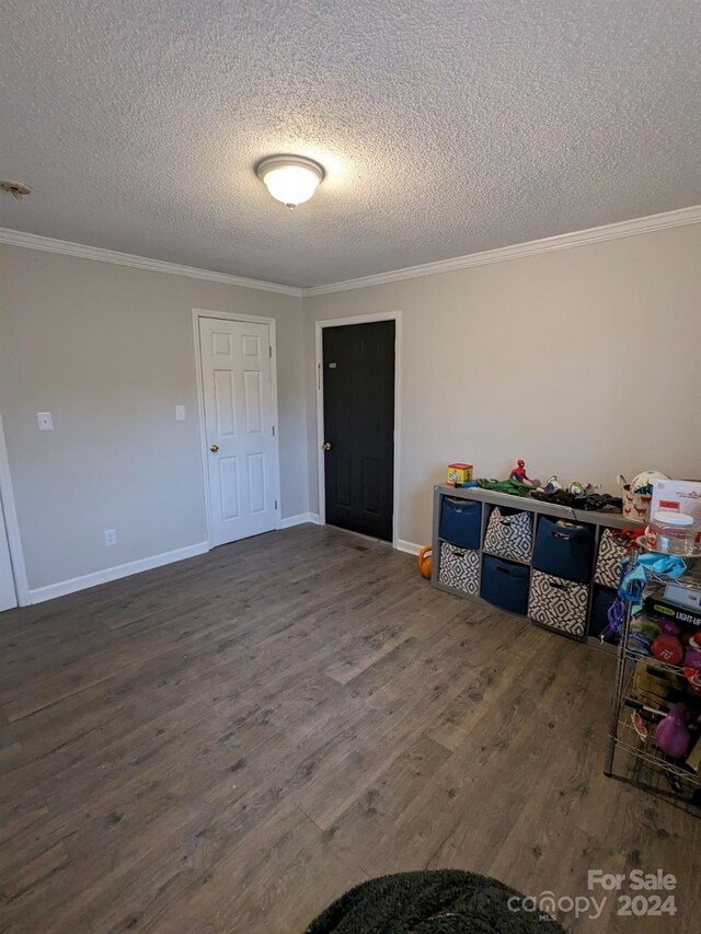 interior space with dark hardwood / wood-style floors, a textured ceiling, and crown molding