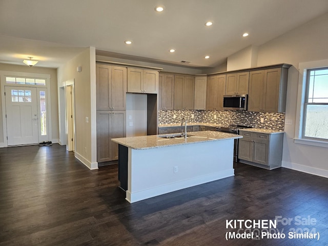 kitchen featuring lofted ceiling, dark wood-type flooring, and a kitchen island with sink