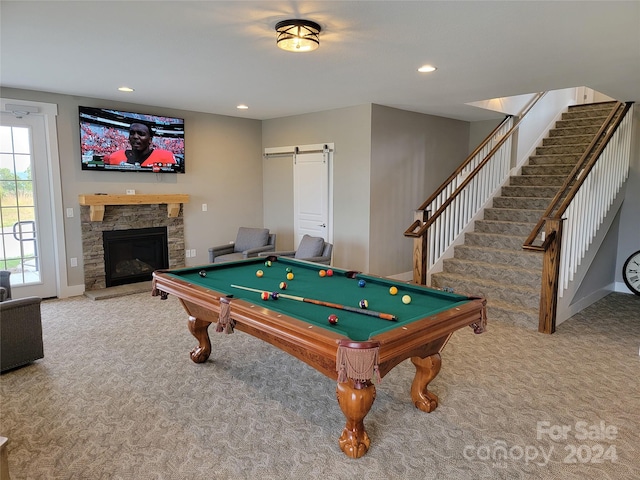 rec room with a stone fireplace, billiards, a barn door, and carpet flooring