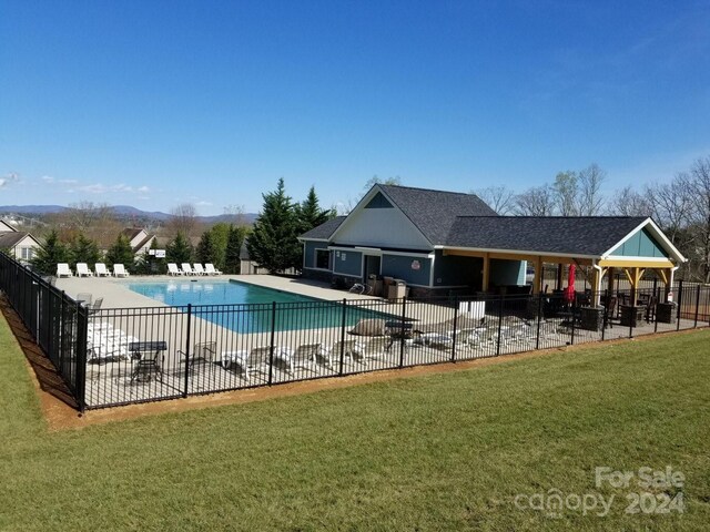 view of pool with a patio and a lawn