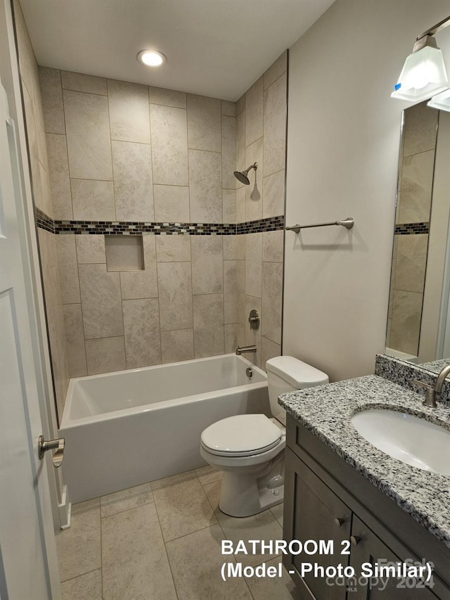 full bathroom with tiled shower / bath, toilet, vanity with extensive cabinet space, and tile floors