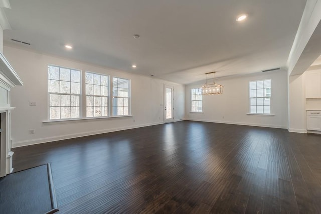 unfurnished living room with dark hardwood / wood-style floors and a chandelier