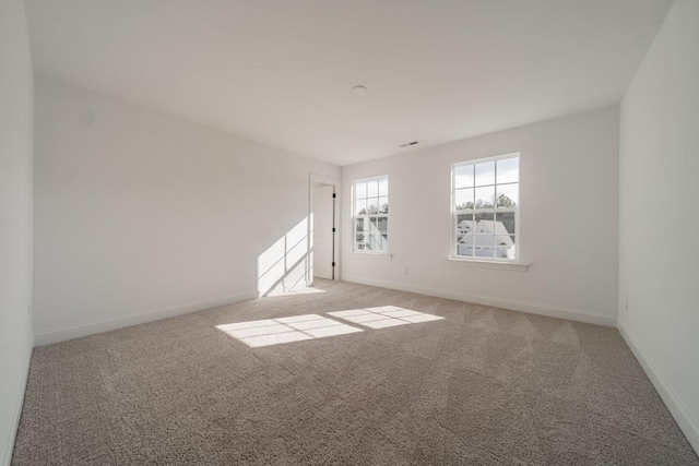 unfurnished room featuring light carpet