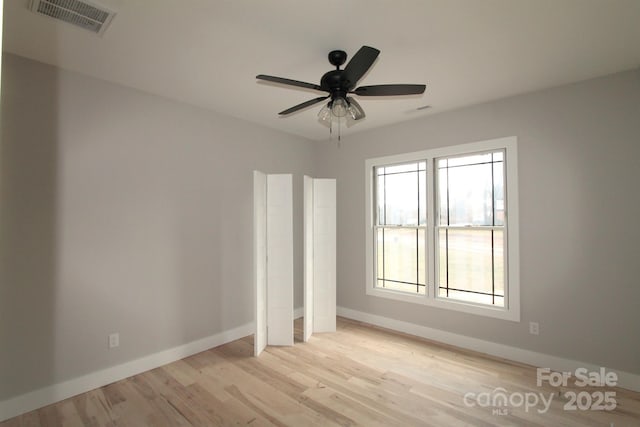 empty room with ceiling fan and light wood-type flooring