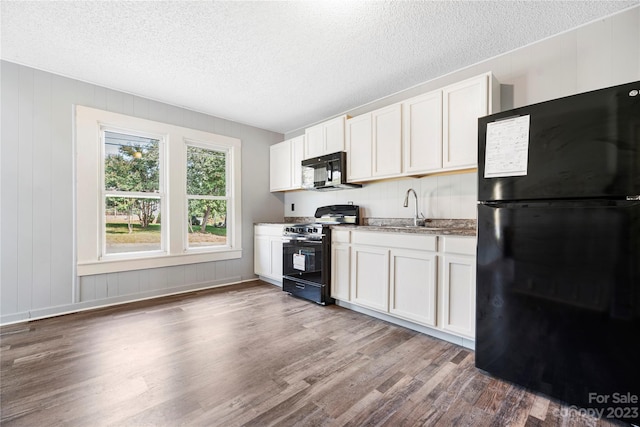 kitchen featuring white cabinets, a textured ceiling, dark hardwood / wood-style floors, and black appliances