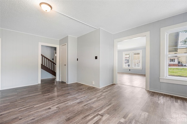 unfurnished room featuring a textured ceiling and dark hardwood / wood-style floors