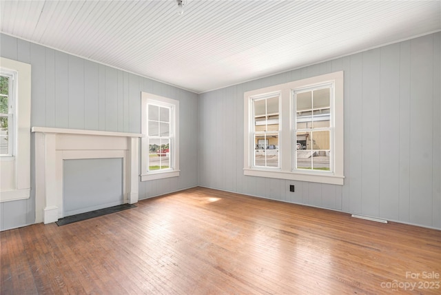 unfurnished living room with a fireplace, plenty of natural light, and hardwood / wood-style flooring