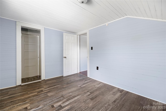 unfurnished bedroom featuring vaulted ceiling, dark hardwood / wood-style floors, and a closet