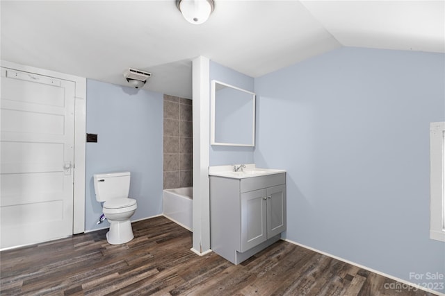 full bathroom with washtub / shower combination, wood-type flooring, lofted ceiling, toilet, and vanity