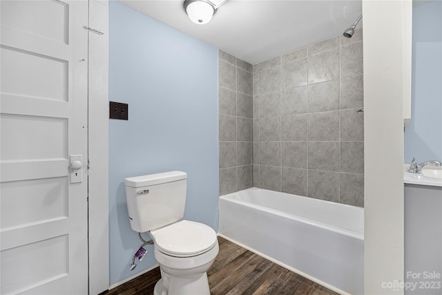 full bathroom with tiled shower / bath combo, vanity, toilet, and hardwood / wood-style flooring