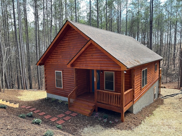 log-style house featuring covered porch