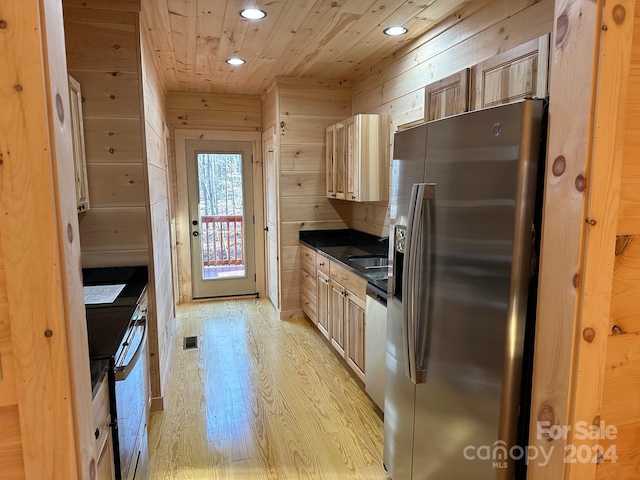 kitchen featuring sink, light hardwood / wood-style flooring, stainless steel appliances, wooden ceiling, and wooden walls