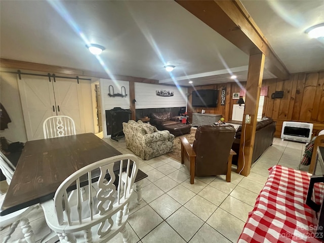 basement featuring a barn door, wood walls, and light tile floors