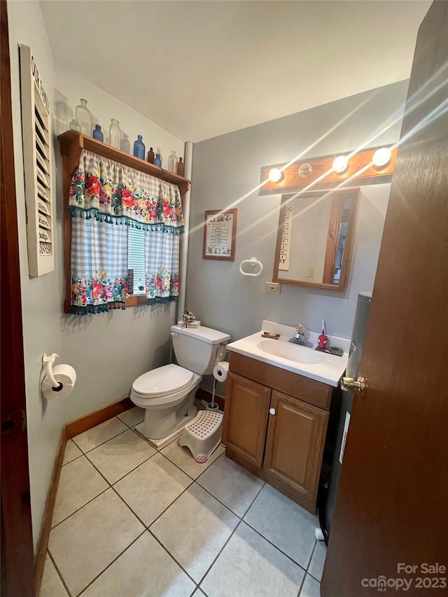 bathroom featuring toilet, tile floors, and vanity with extensive cabinet space