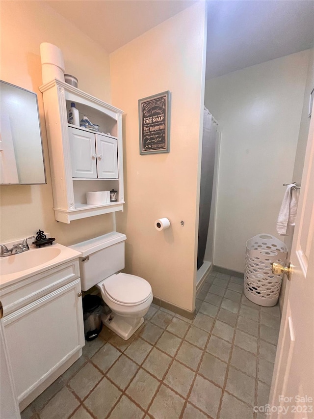 bathroom with toilet, tile floors, and vanity