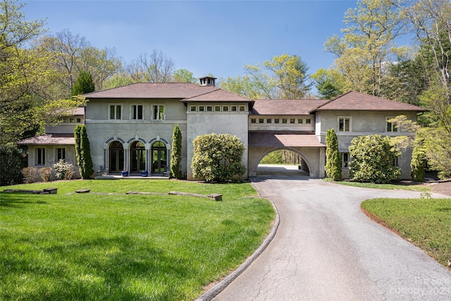 mediterranean / spanish home featuring a front yard