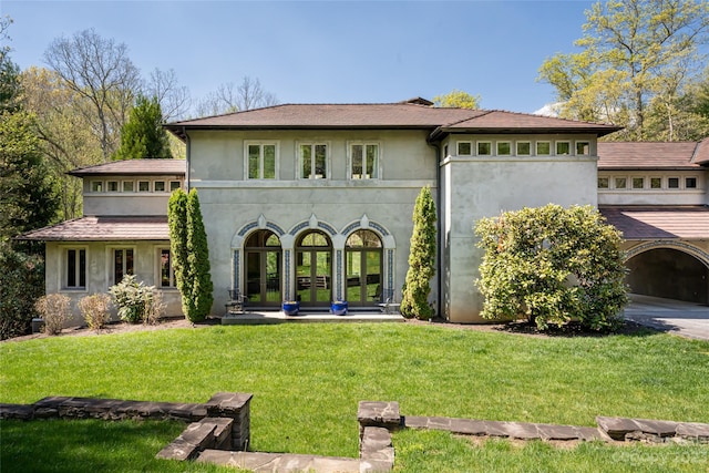 back of house featuring a lawn and french doors