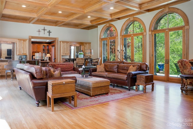 living room featuring plenty of natural light, coffered ceiling, light hardwood / wood-style floors, and french doors