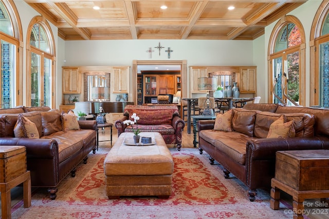 living room with coffered ceiling, beamed ceiling, ornamental molding, and a wealth of natural light