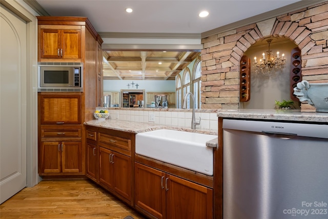 kitchen with coffered ceiling, appliances with stainless steel finishes, sink, light hardwood / wood-style flooring, and a chandelier