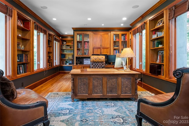 office area featuring crown molding, built in shelves, and light hardwood / wood-style floors