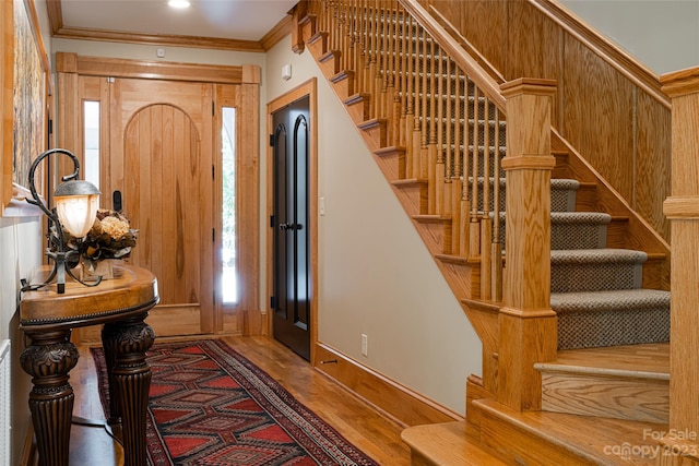 foyer entrance featuring crown molding and hardwood / wood-style flooring