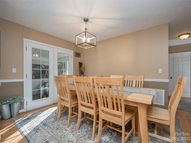 dining area featuring hardwood / wood-style flooring and a chandelier