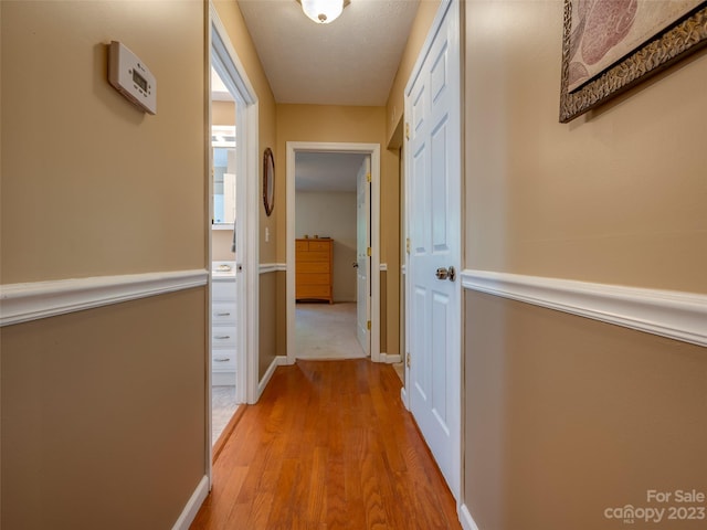 hall featuring a textured ceiling and light wood-type flooring