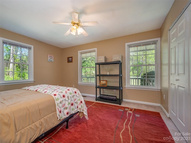 carpeted bedroom featuring multiple windows, a closet, and ceiling fan