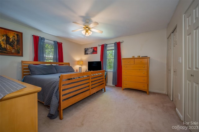 carpeted bedroom featuring multiple windows, a closet, and ceiling fan