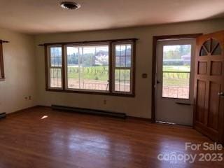 interior space with dark hardwood / wood-style flooring and baseboard heating