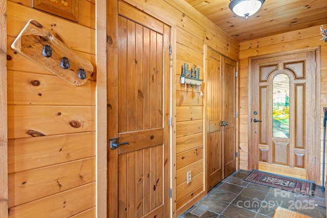 entrance foyer featuring wooden ceiling and wood walls