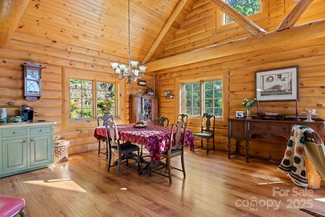 dining room with log walls, high vaulted ceiling, and a notable chandelier