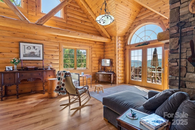 living room featuring log walls, light hardwood / wood-style flooring, high vaulted ceiling, and wooden ceiling