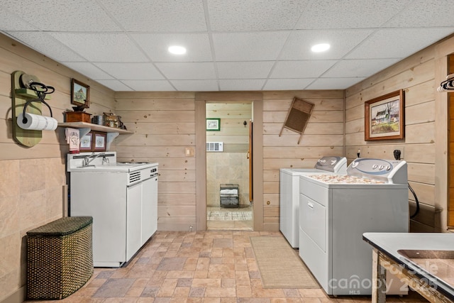 laundry room with sink, wooden walls, and washing machine and clothes dryer