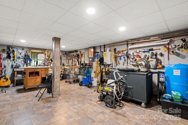 basement featuring a drop ceiling and a workshop area