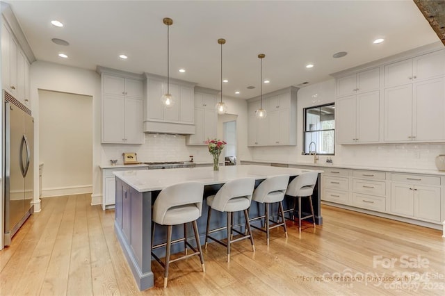 kitchen with stainless steel appliances, a center island, and light wood-type flooring