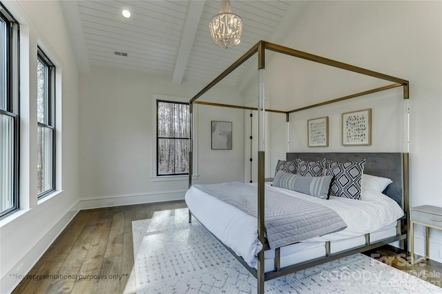 bedroom featuring an inviting chandelier, dark wood-type flooring, and lofted ceiling with beams