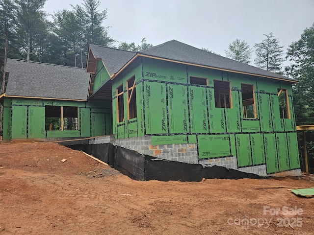 view of side of property featuring a shingled roof