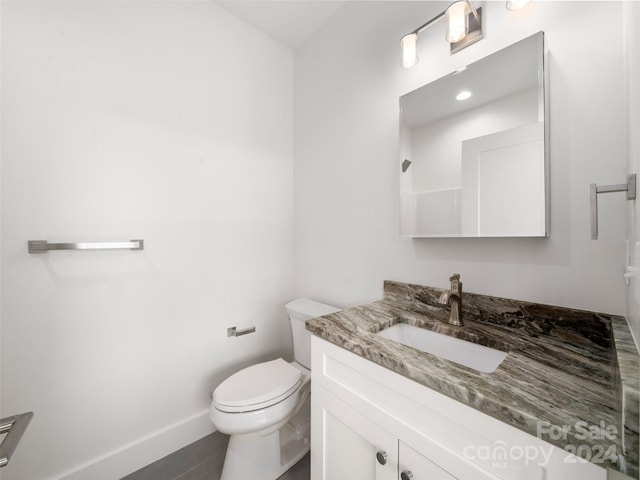 bathroom featuring toilet, tile patterned flooring, and vanity