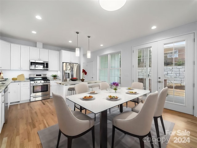 dining room with light wood-type flooring and french doors