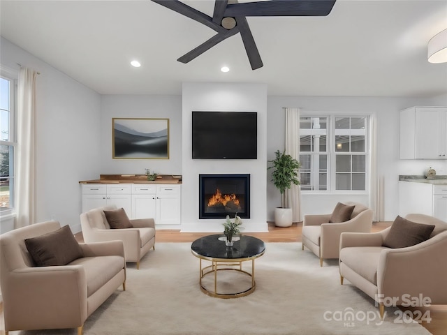 living room featuring ceiling fan and light hardwood / wood-style flooring