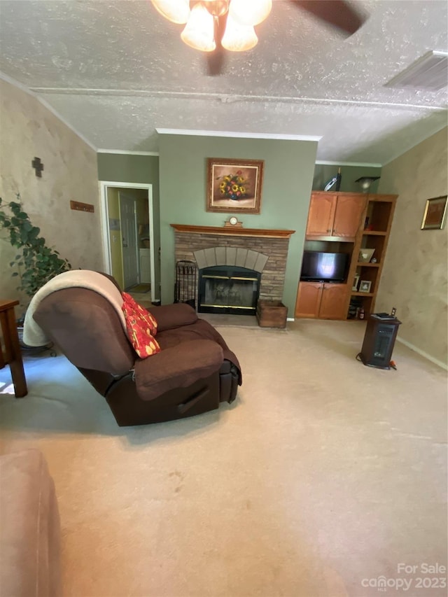 living room featuring ceiling fan, light colored carpet, a fireplace, and a textured ceiling